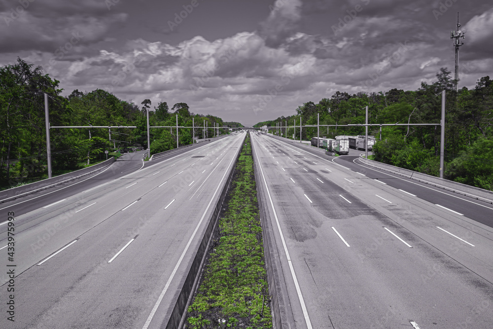 Motorway in Germany with 8 lanes completely empty dramatic in black an white with green plants