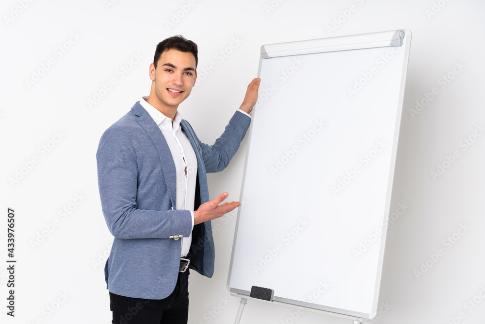 Young caucasian handsome man isolated on purple background giving a presentation on white board Young caucasian handsome man isolated on purple background giving a presentation on white board