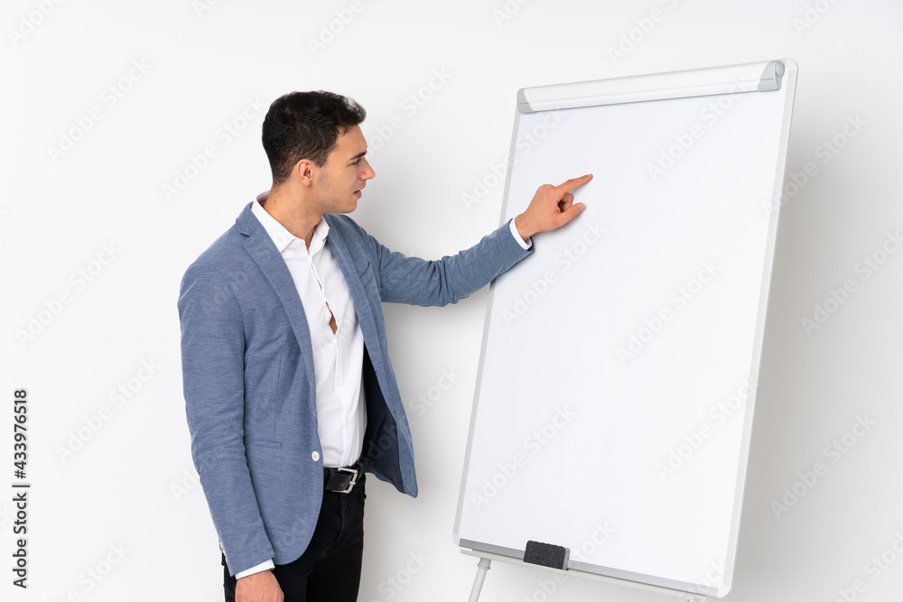 Young caucasian handsome man isolated on purple background giving a presentation on white board Young caucasian handsome man isolated on purple background giving a presentation on white board