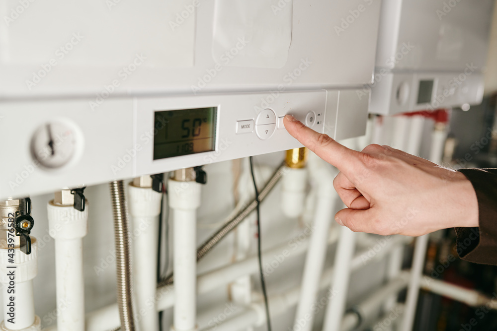 A hand of technician pressing button of air conditioner A hand of technician pressing button of air conditioner