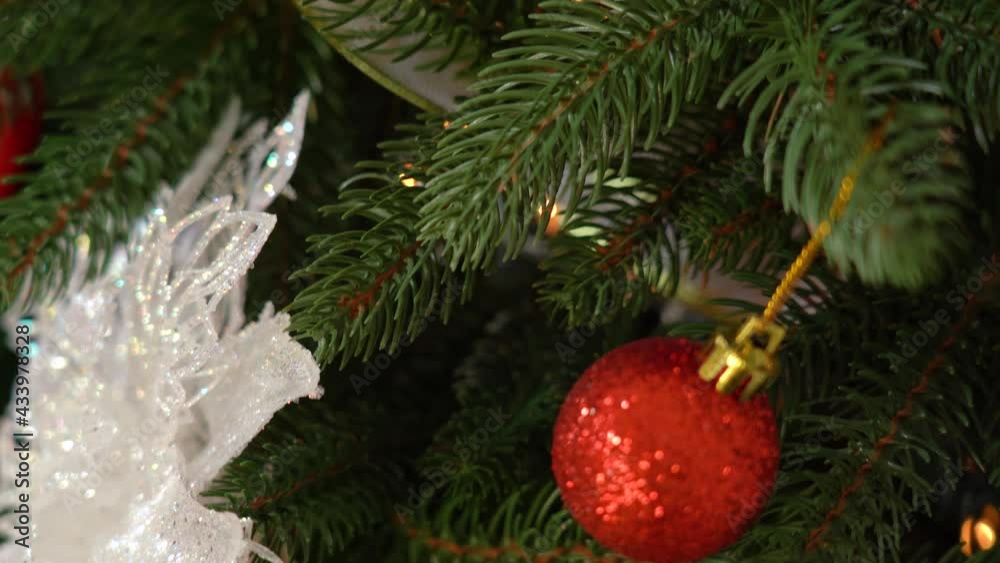 Abstract holiday xmas background. Closeup view 4k stock video footage of traditional green Christmas pine tree decorated with red, pink, white, gold and other colors shiny balls