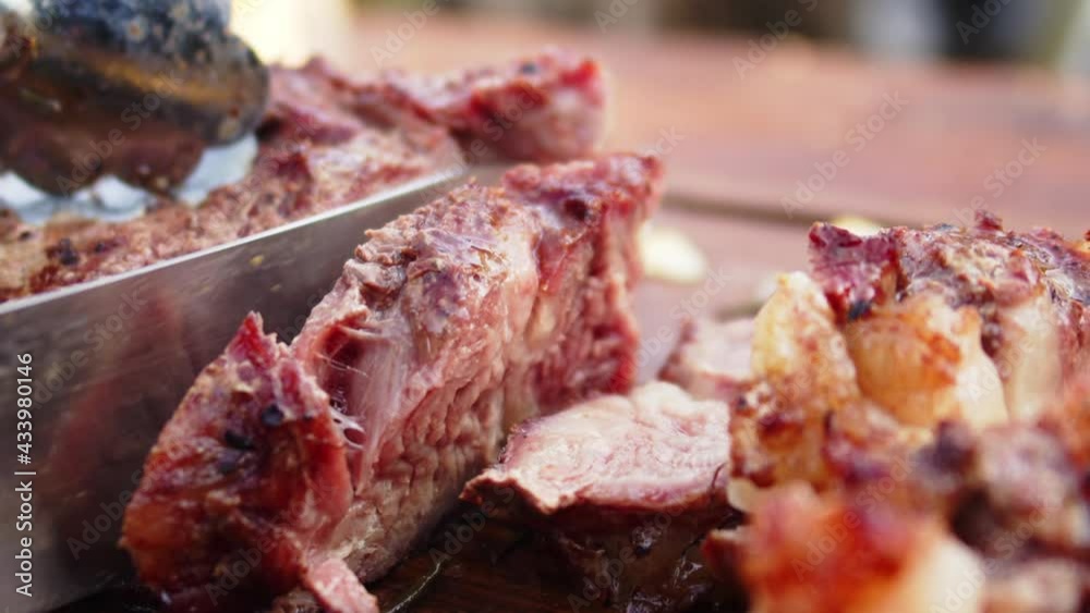 Meat being cut into pieces with a knife on a wooden board Meat being cut into pieces with a knife on a wooden board