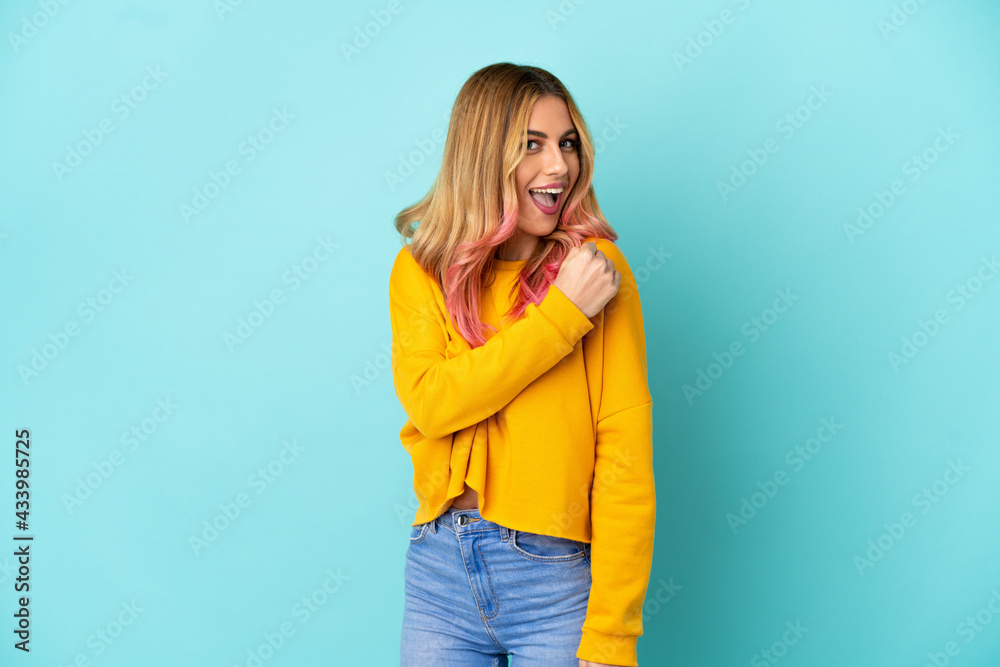 Young woman over isolated blue background celebrating a victory Young woman over isolated blue background celebrating a victory