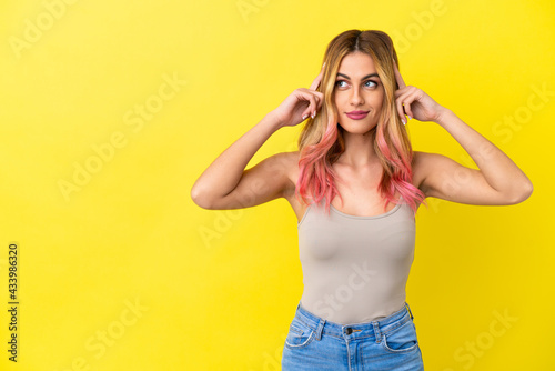 Young woman over isolated yellow background having doubts and thinking