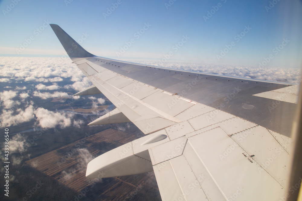 The wing of the plane. View from the porthole.the plane.Flying by plane. The wing of the plane. View from the porthole.the plane.Flying by plane.