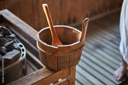 Sauna bucket with water in it, in finnish sauna room beside the stone.