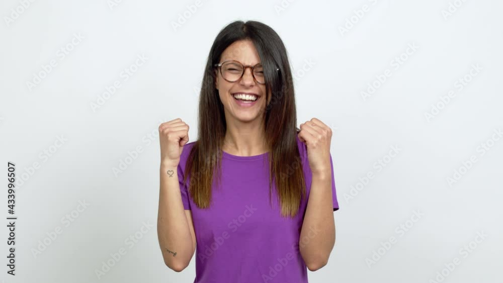 Young woman with glasses celebrating a victory over isolated background Young woman with glasses celebrating a victory over isolated background