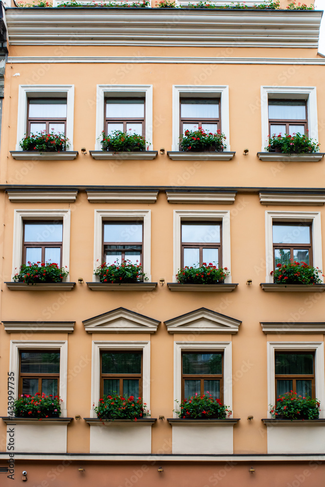 Fototapeta premium Facade of an old European house with windows and decorated with flowers