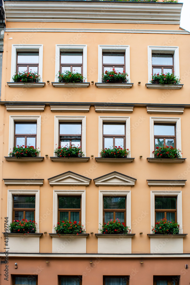 Facade of an old European house with windows and decorated with flowers