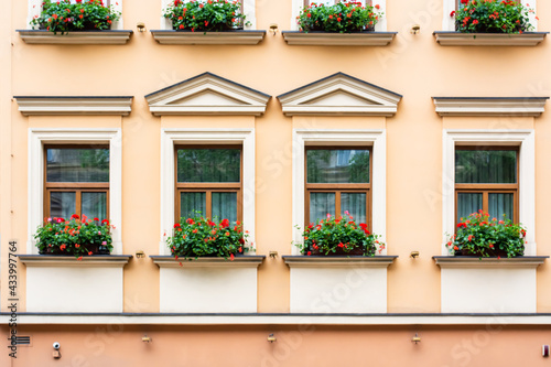 Facade of an old European house with windows and decorated with flowers