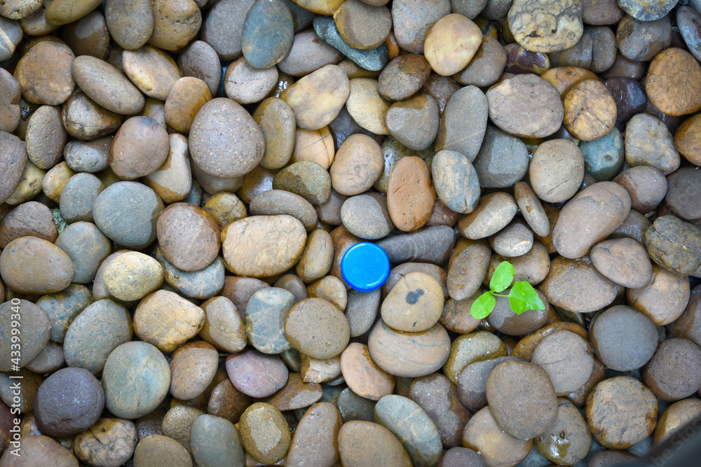 Blue plastic bottle cap on pebbles. soil and ground pollution. Environmental pollution problem concept Blue plastic bottle cap on pebbles. soil and ground pollution. Environmental pollution problem concept