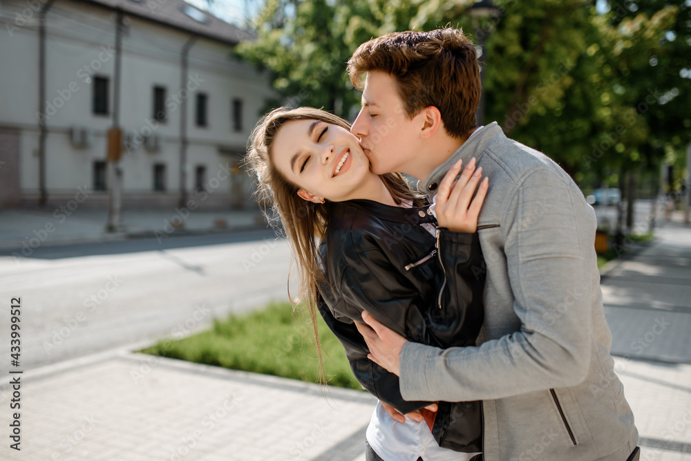 young happy beautiful couple laughing and hugging in the street. . young happy beautiful couple laughing and hugging in the street. .
