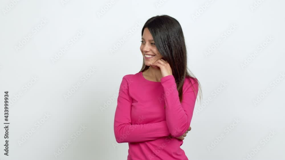 Young woman standing and looking to the side over isolated background Young woman standing and looking to the side over isolated background