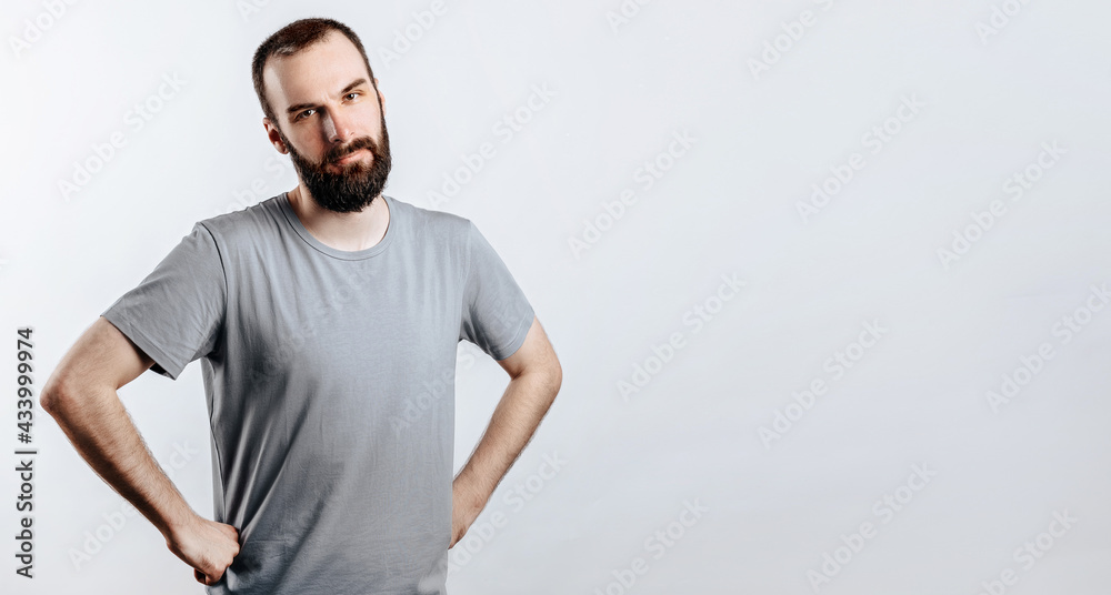 Portrait of cheerful young man smiling while looking at camera holding hands out to sides on white background with space for advertising mock up Portrait of cheerful young man smiling while looking at camera holding hands out to sides on white background with space for advertising mock up