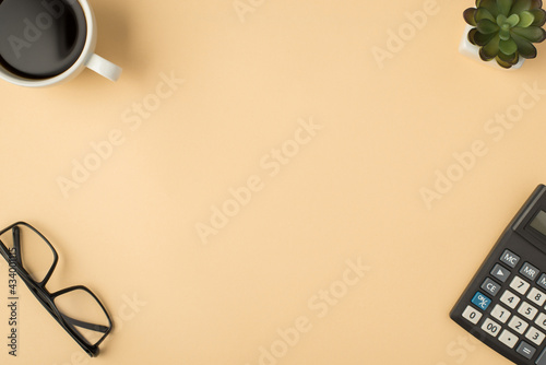 Top view photo of cup glasses flowerpot and calculator on isolated beige background with copyspace in the middle