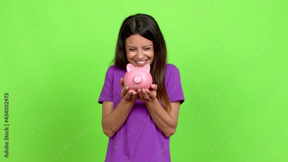 Young woman unhappy and holding a piggybank over isolated background Young woman unhappy and holding a piggybank over isolated background