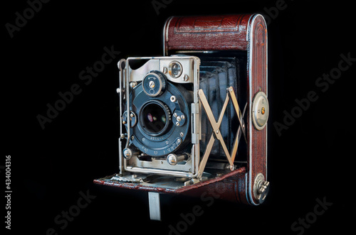 Vintage folding camera isolated on the black background. Close shoot of the folding camera from 1930. 