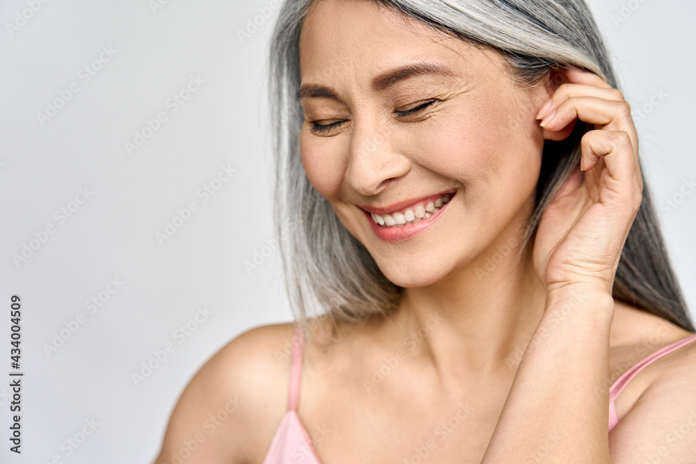 Obraz premium Portrait of gorgeous happy middle aged mature cheerful asian woman, senior older 50s lady pampering her face eyes closed isolated on white. Ads of lifting anti wrinkle skin care, spa. Copy space.