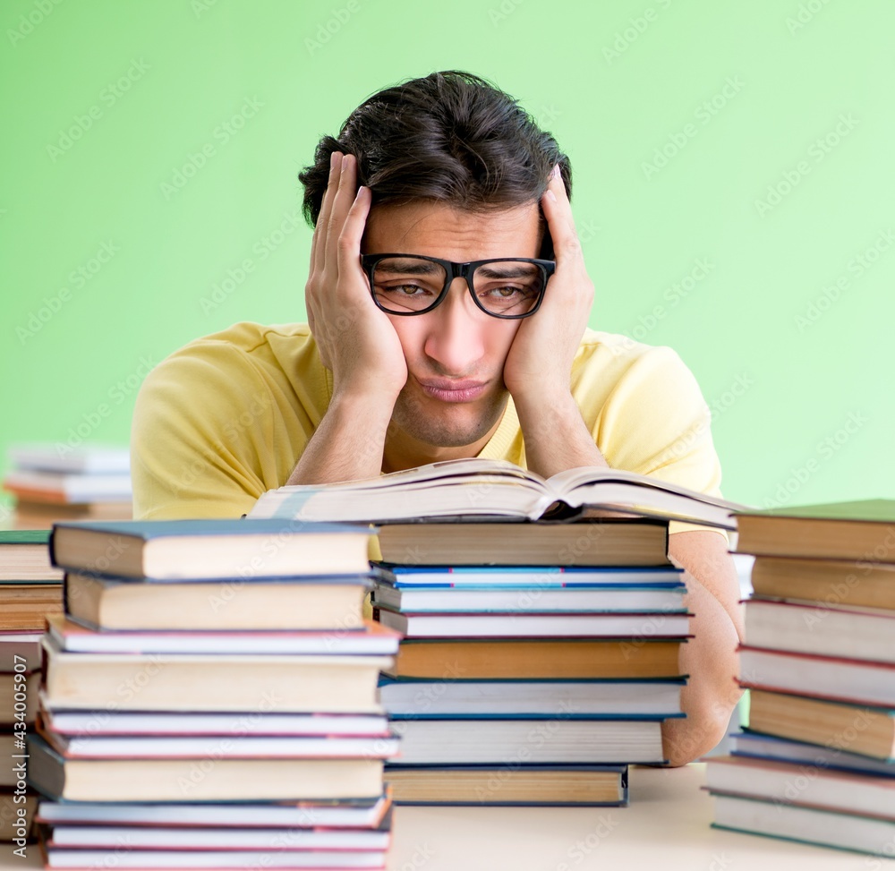 Student with too many books to read before exam Student with too many books to read before exam