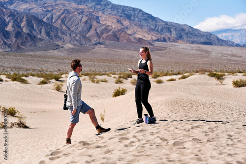 A family with a teenage girl is hiking in Mesquite Flat Sand Dunes, Death Valley National Park, California, USA during their road trip from Las Vegas to San Francisco in March 2021 amidst COVID-19