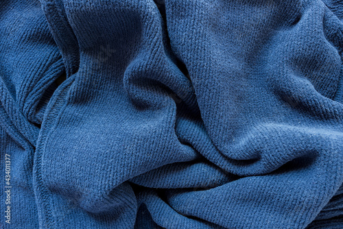 old navy blue zipper down sweater - photographed from above with low or raking light - emphasis on texture and folds