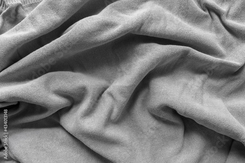 grey cotton fabric - photographed from above with low or raking light - emphasis on texture and folds