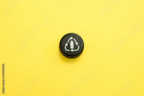 Bottle cap recycle logo on a yellow background 