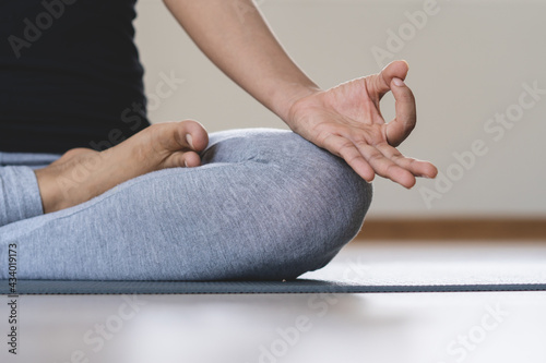 Yoga and meditation lifestyles. close up view of young beautiful woman practicing yoga namaste pose in the living room at home.