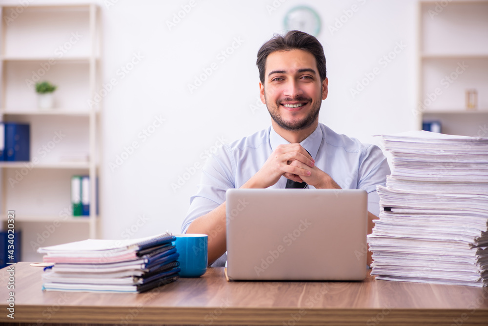 Young businessman employee unhappy with excessive work in the office