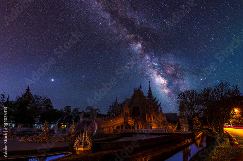 The Milky Way galaxy in the sky above Wat Rong Khun, Chiang Rai, Thailand. Long exposure photograph, with grain.Image contain certain grain or noise and soft focus.