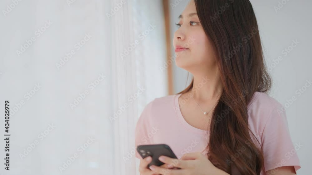 Asian beautiful girl smiling while chatting on mobile phone with lover Asian beautiful girl smiling while chatting on mobile phone with lover