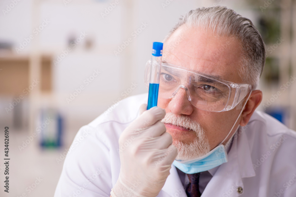 Old male chemist working in the lab during pandemic Old male chemist working in the lab during pandemic
