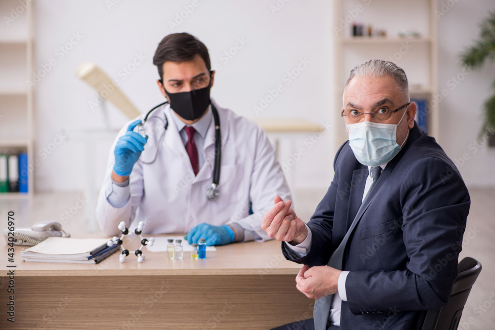 Obraz premium Old businessman visiting young male doctor in vaccination concep