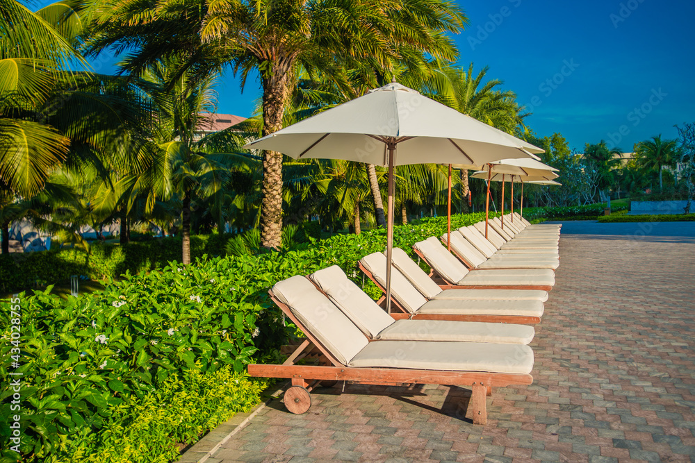 empty sun chair and umbrellas at early morning, tropical paradise postcard
