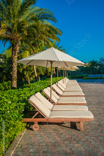 empty sun chair and umbrellas at early morning  tropical paradise postcard