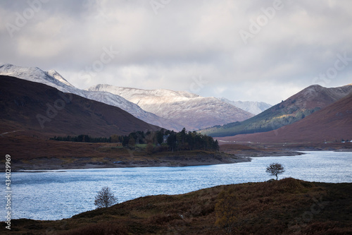 Autumn landscape in Highlands, Scotland, United Kingdom. Beautiful mountains with snow in background.