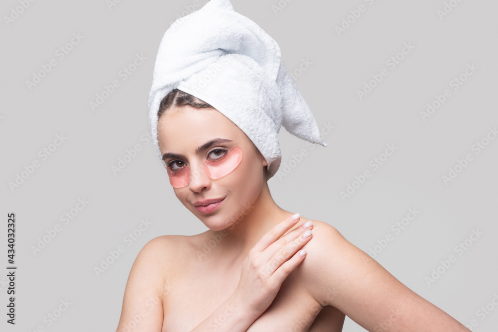 Sensual woman applying eye patches. Close up portrait girl with towel on head. Eyes mask cosmetic patches woman face closeup. Young woman in terry towel use patch. Sensual woman applying eye patches. Close up portrait girl with towel on head. Eyes mask cosmetic patches woman face closeup. Young woman in terry towel use patch.