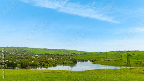 Lake by a village with green hills