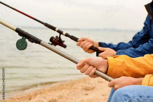 Father and son fishing together on river, closeup
