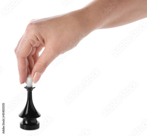 Female hand with chess piece on white background