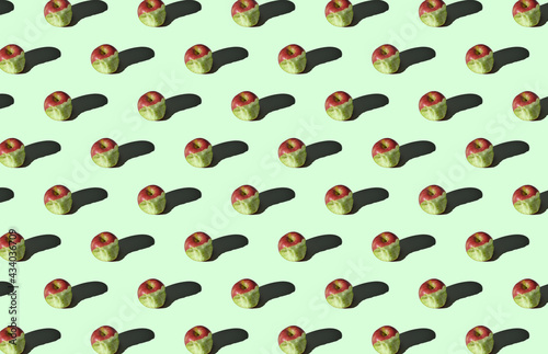 Pattern of bitten apples on green background