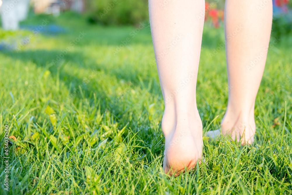 Feet of a child on the lawn on the grass. Selective focus. Kid.