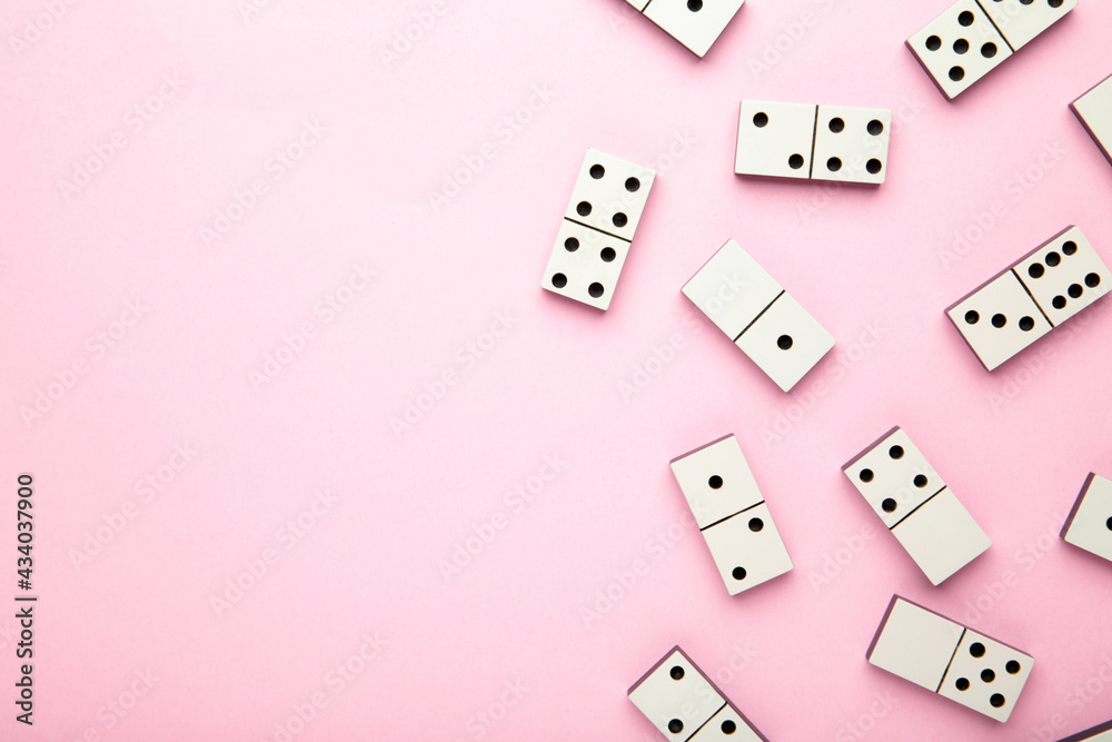 Domino pieces on the pink background with copy space Domino pieces on the pink background with copy space