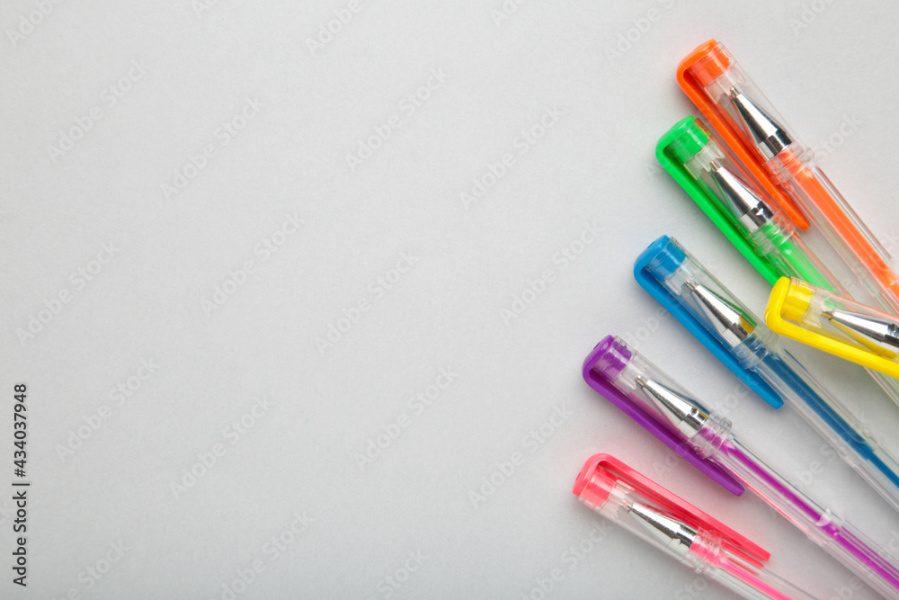 Different colors pens on grey background. Top view Different colors pens on grey background. Top view