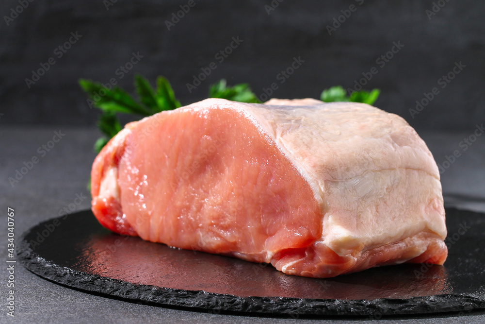 Raw pork loin. Pork meat on a gray background. Closeup.