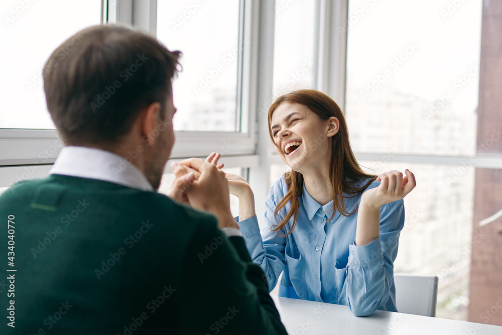 man and woman sitting at the table work colleagues communication fun man and woman sitting at the table work colleagues communication fun