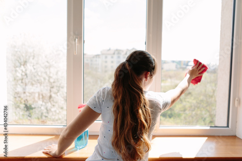 Beautiful woman cleaning window at home Free Download Beautiful woman cleaning window at home - GFXLoad