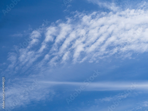 Soft white waves of clouds against the blue sky