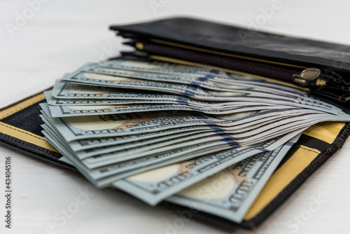 dark leather men's wallet full dollar bills as financial background