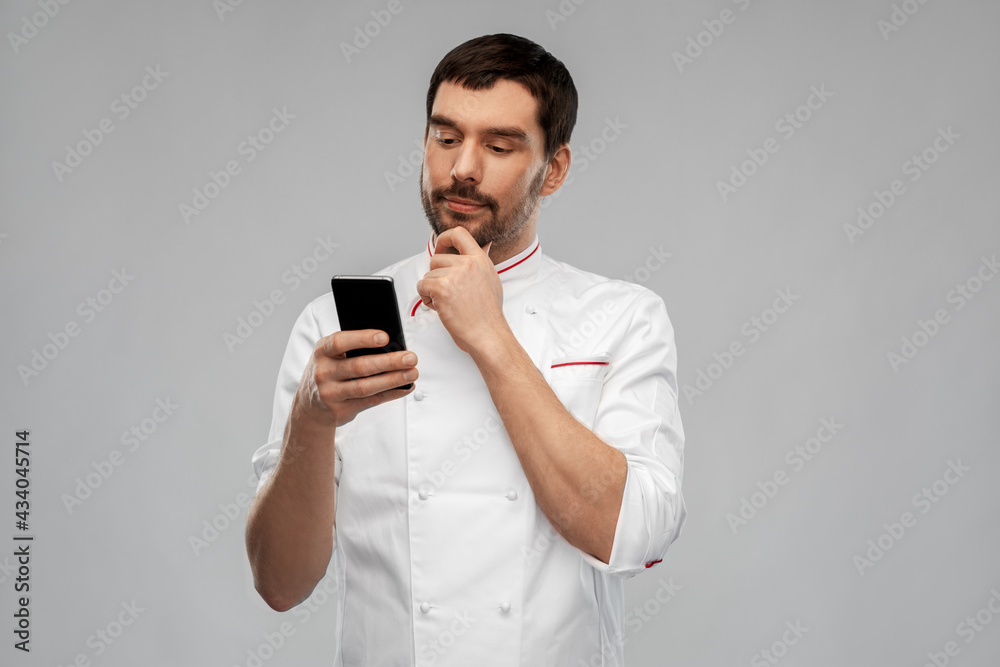 cooking, culinary and people concept - thinking male chef with smartphone over grey background cooking, culinary and people concept - thinking male chef with smartphone over grey background